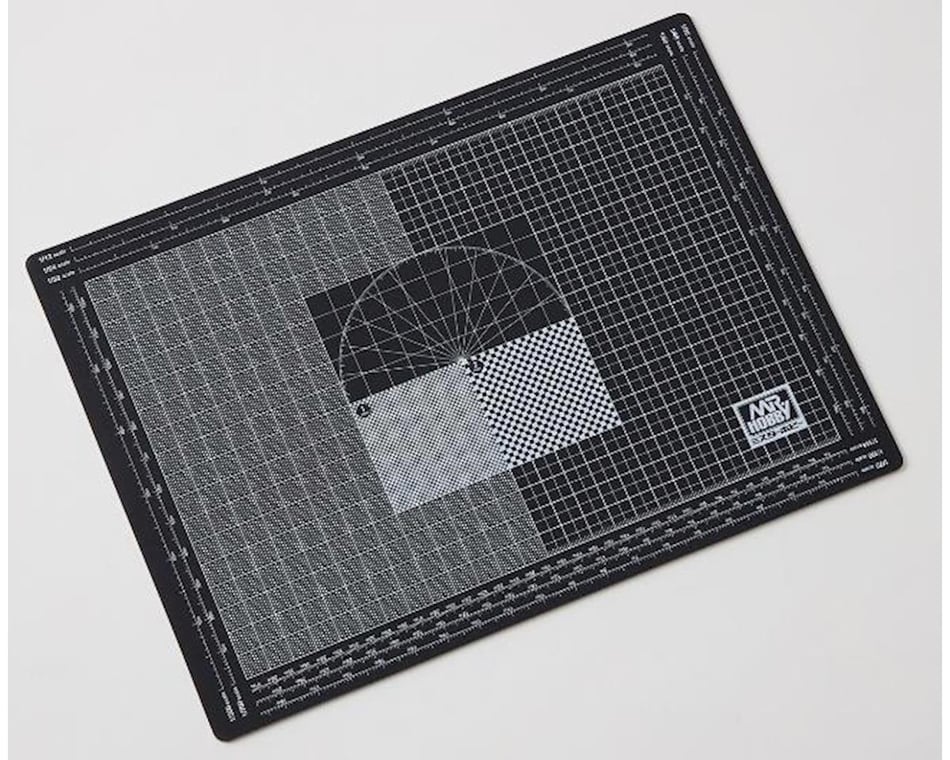 Sharp cutting blade on a green grid hobby mat, measured in inch