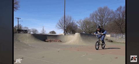 Slow motion gif of a BMX rider doing a barspin.