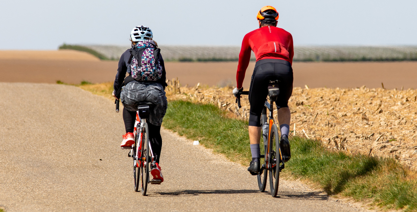 two cyclists riding along a country lane