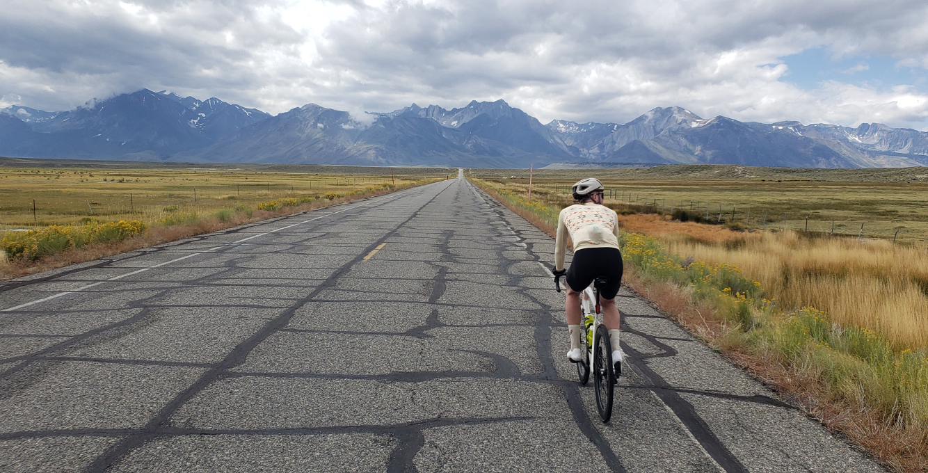 cyclist riding a century ride with mountains in the background