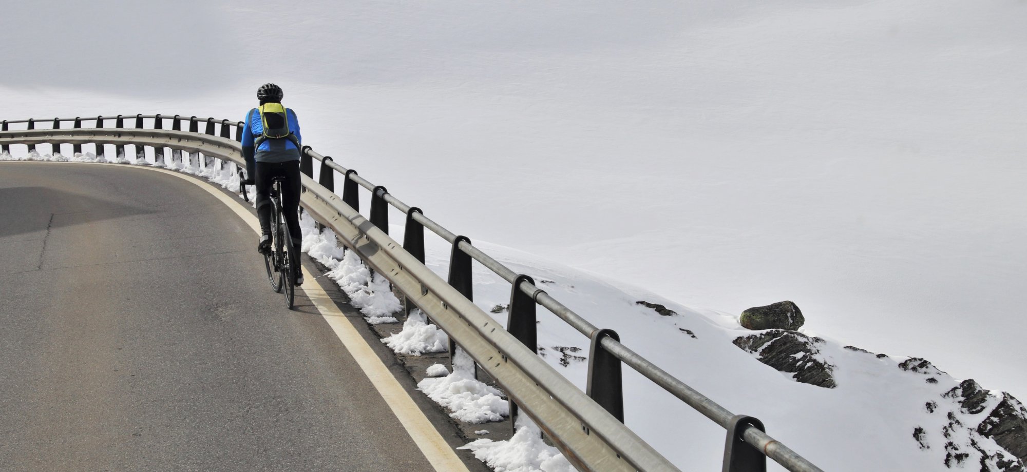 Cyclist riding a bike on snowy road with cold tires