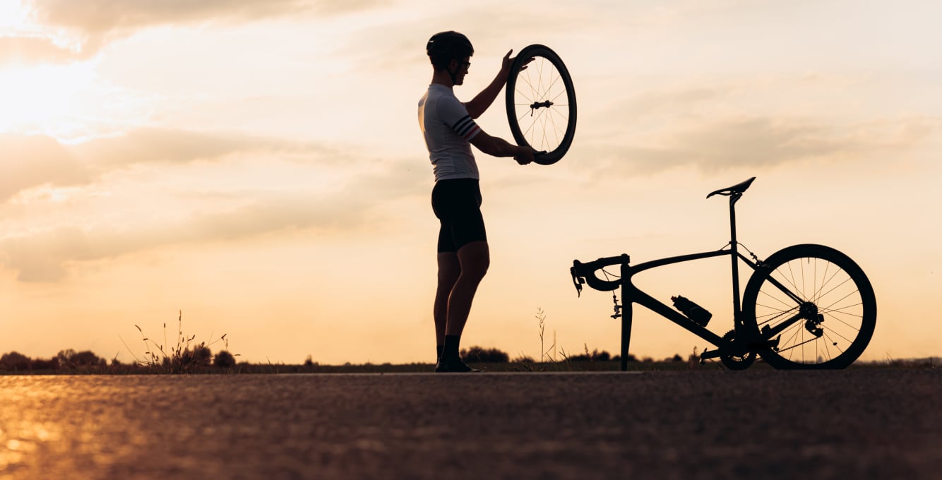 cyclist fixing a flat on the side of the road