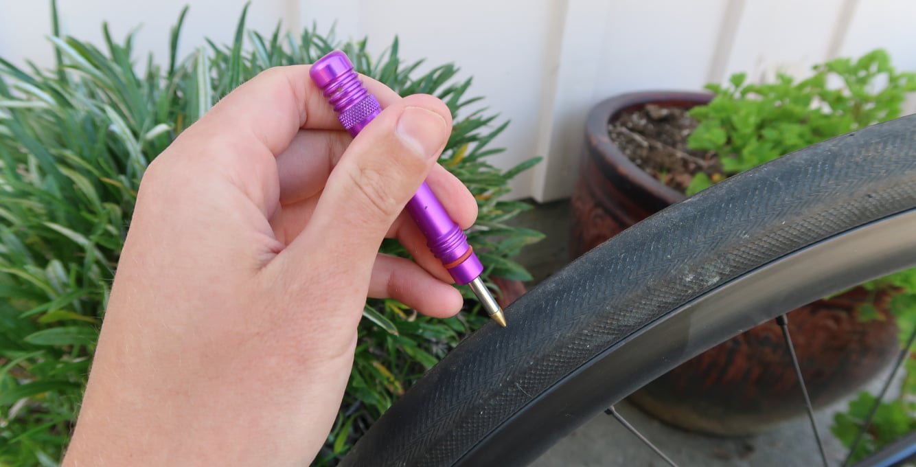 cyclist holding a dynaplug close to tubeless tire