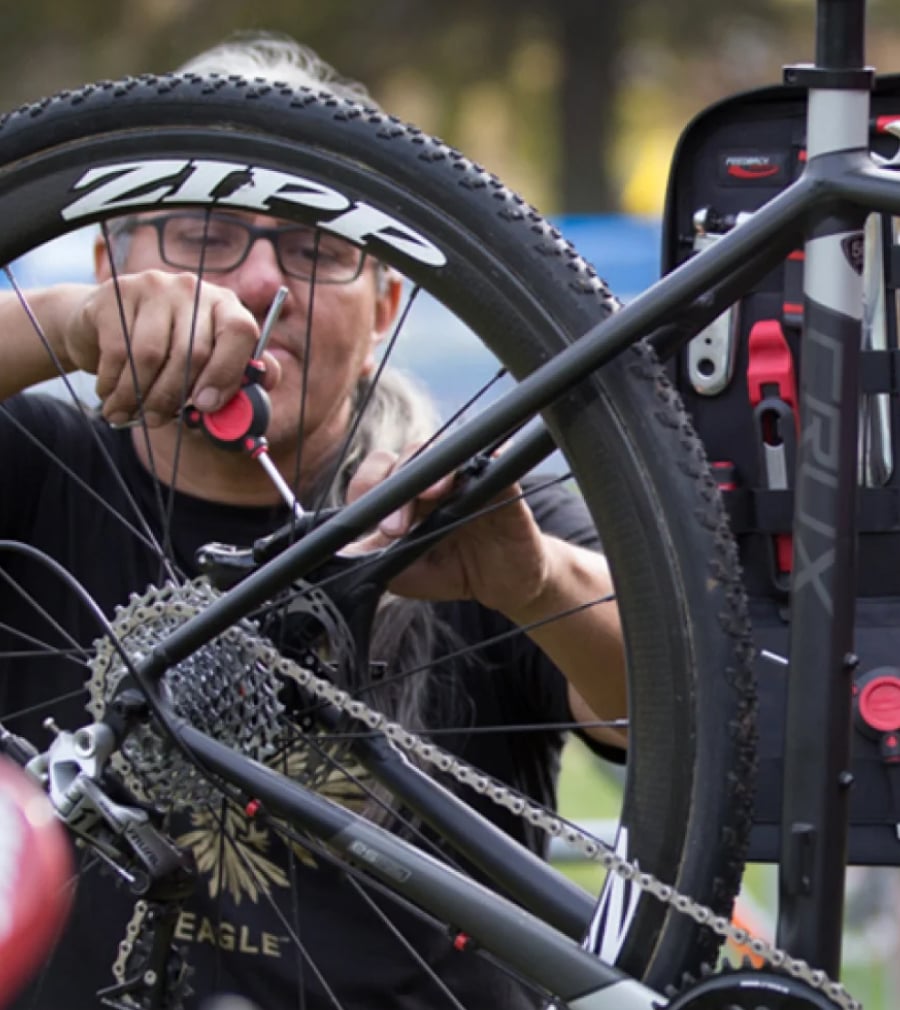 Bicycle mechanic adjusting rear brake caliper