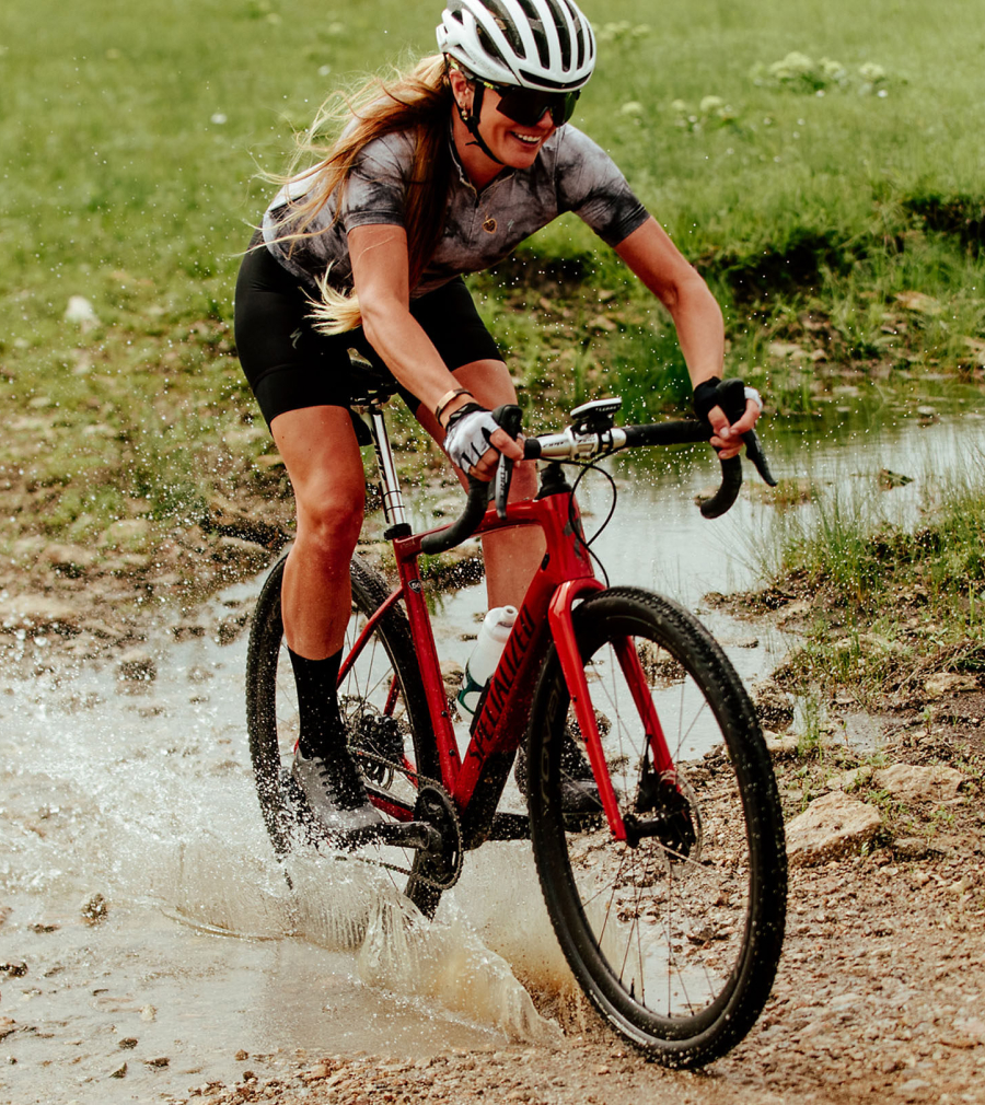 Woman riding gravel bike through creek while wearing S-Works Recon shoes