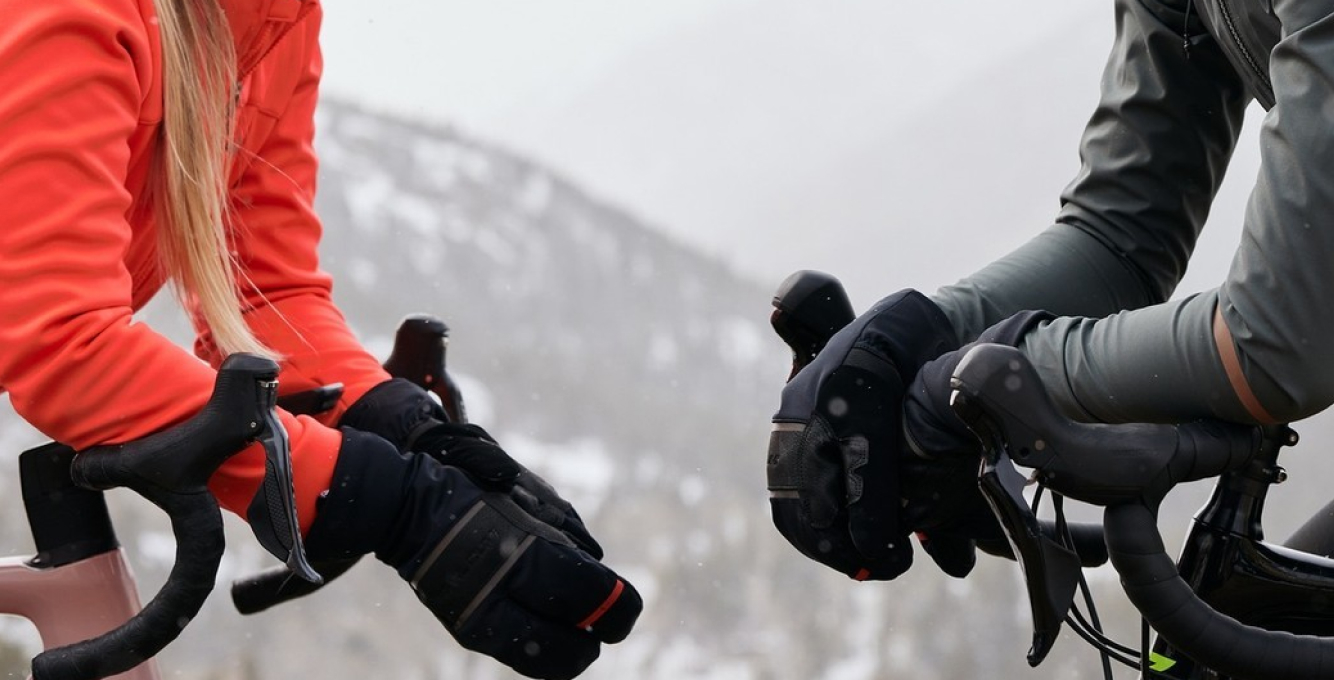 Two winter cyclists wearing winter lobster styled gloves