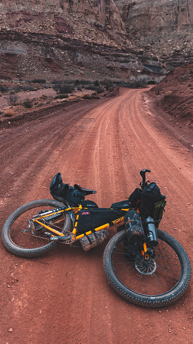 Gravel bike packed with camping gear on the ground