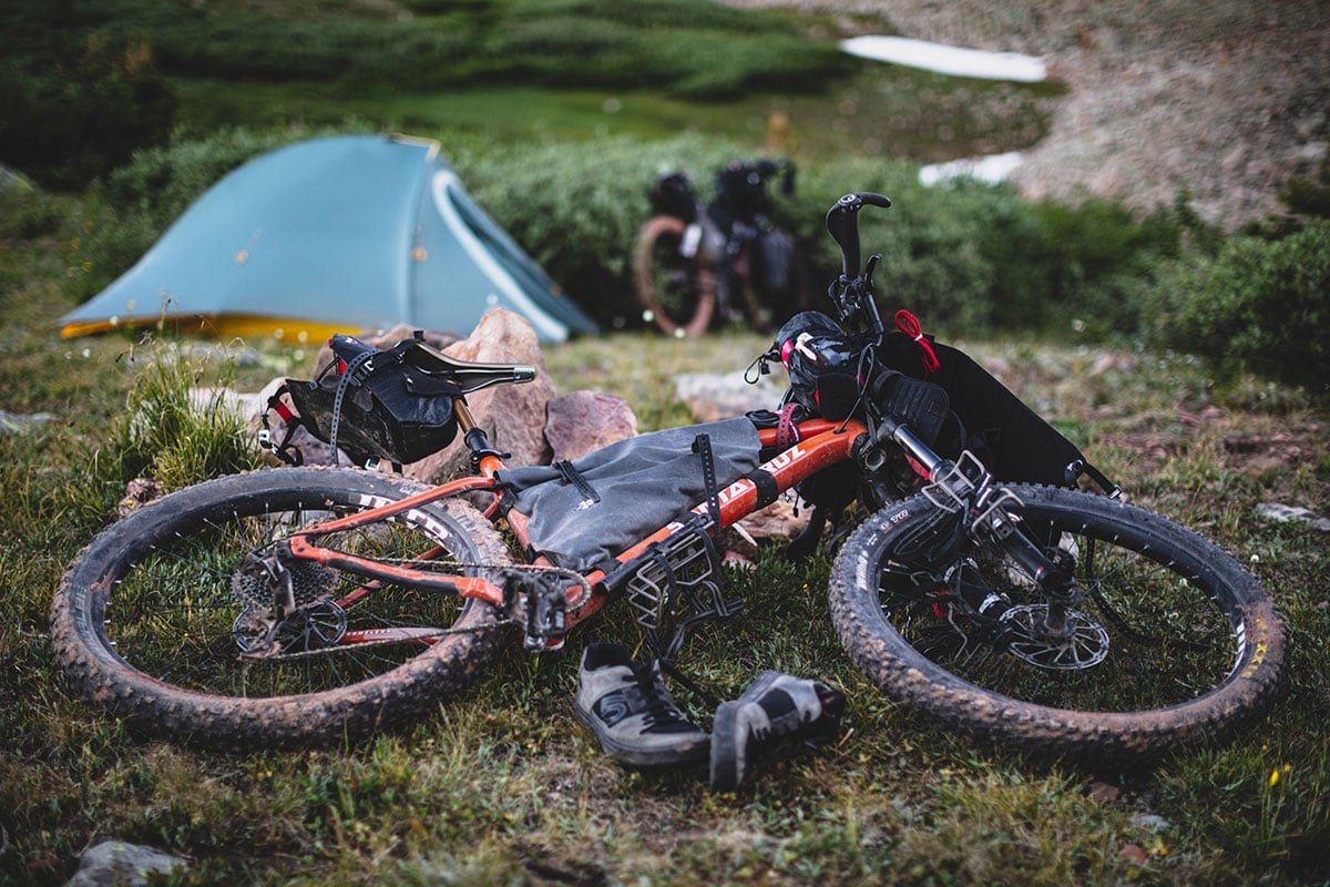 Bikepacking bike laying on the ground at a campsite