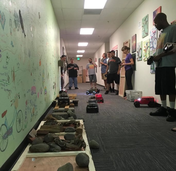 Image: People in a hallway driving RC cars
